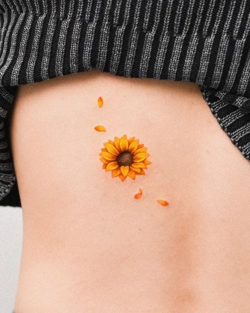 Sunflower Tattoo Meaning, Designs & Placement Ideas 2 Color sunflower tattoo placed on the side of the torso