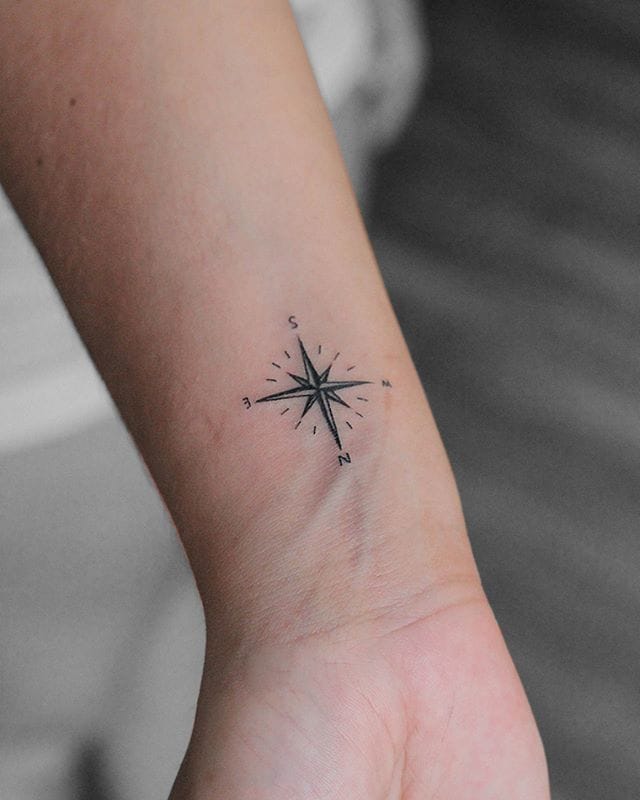 small compasss tattoo on the wirst