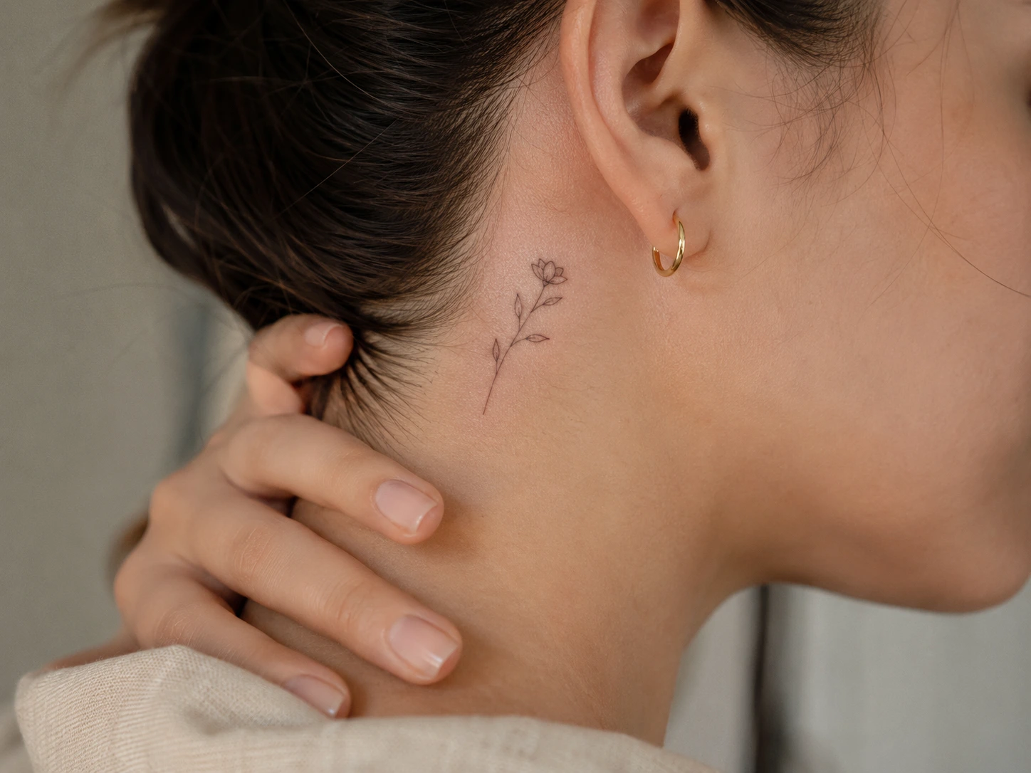 Close-up of a small fine-line tattoo in a delicate placement during normal healing