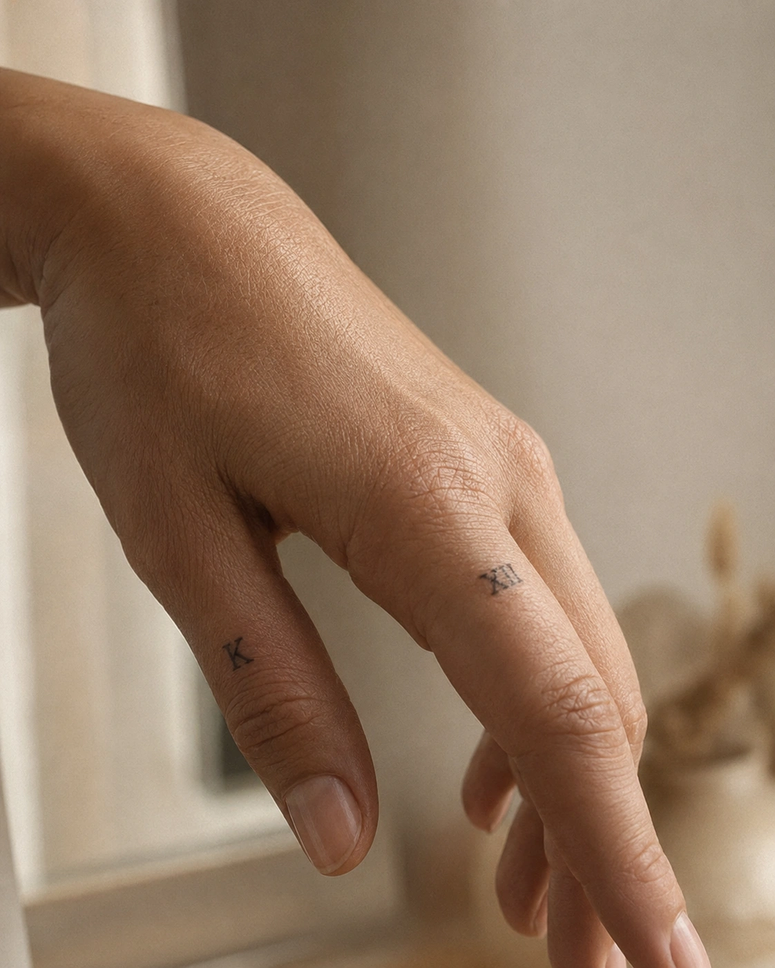 Small initial and number finger tattoos